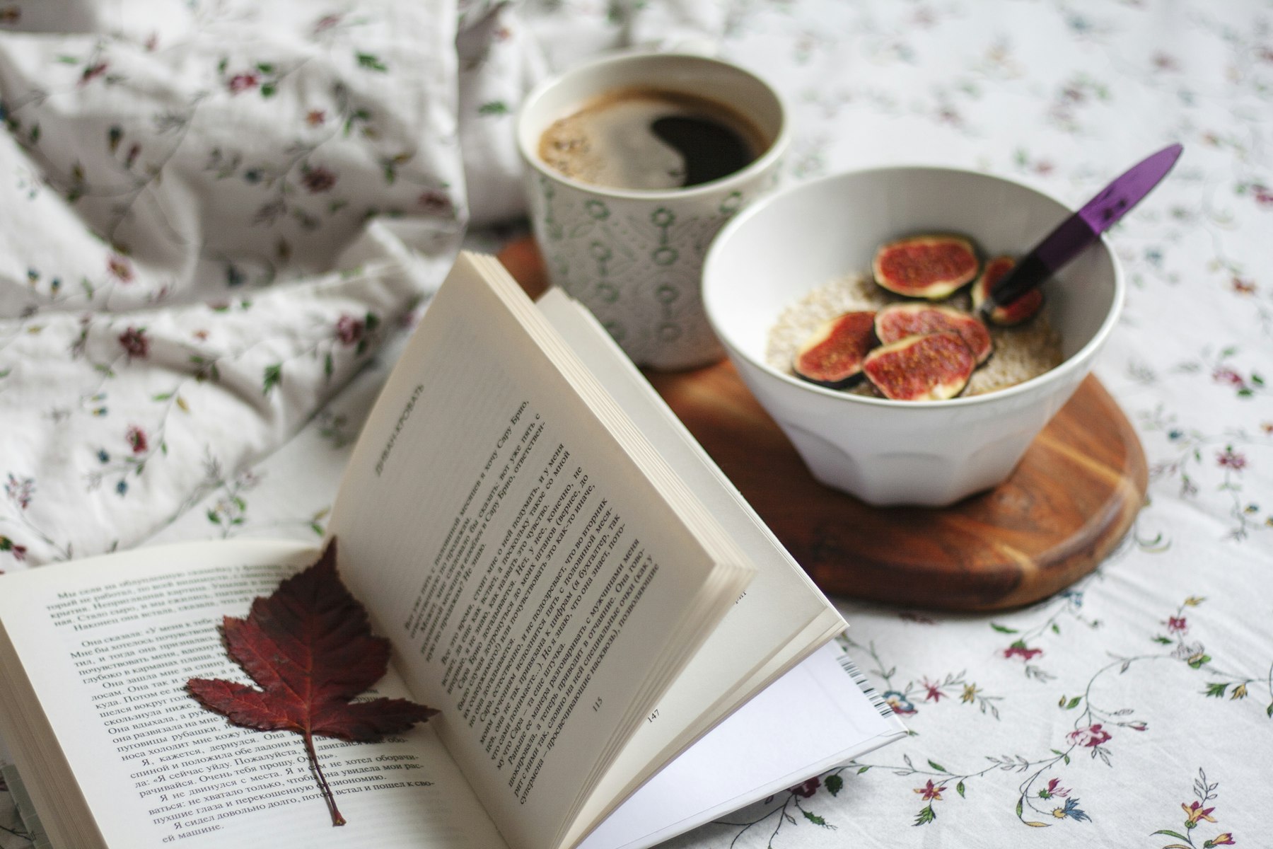 Un livre ouvert posé sur un lit avec un café